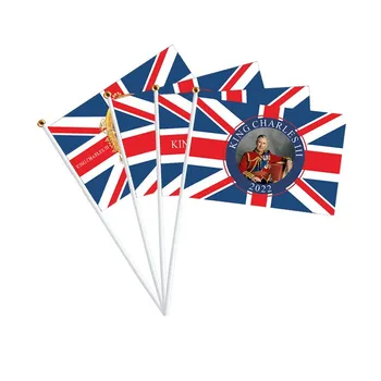 הבריטי המלך צ ' ארלס השלישי-יד לנופף את הדגל המלך המולך ביד מנופפת דגל קטן.
